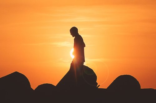 person standing on rock platform