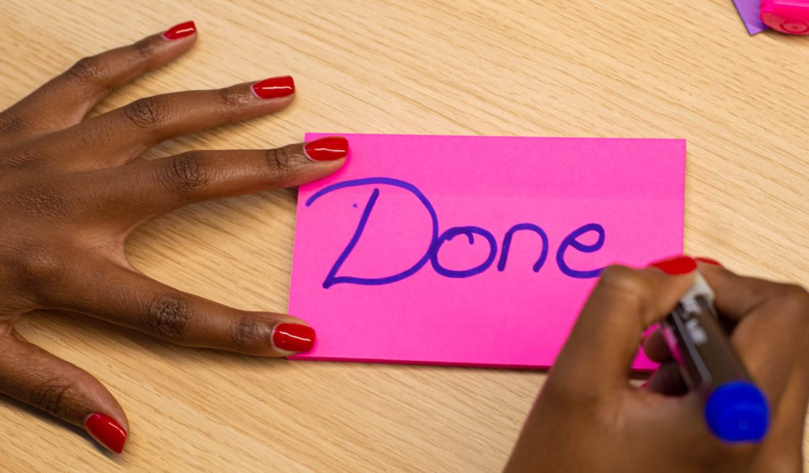 person with red manicure holding purple paper