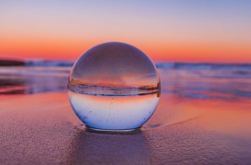 clear glass ball on gray sand during sunset