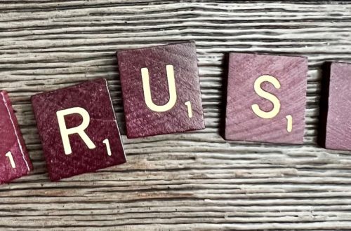 trust spelled with wooden letter blocks on a table